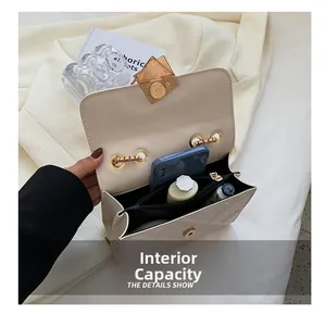 Détail montrant la capacité intérieure et la poche zippée d'un sac bandoulière matelassé