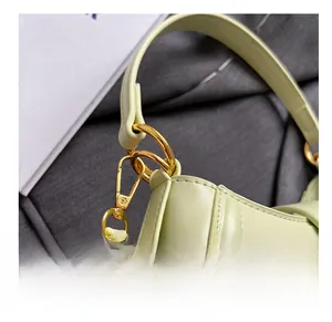 Detail of mint green leather handbag showing gold metal rings and lobster clasp hardware