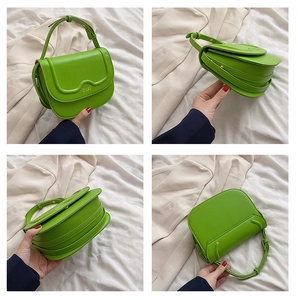 Vista dettagliata della borsa verde con patta a onde e struttura laterale a fisarmonica