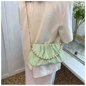 Détail du sac nuage plissé vert menthe avec chaîne de perles et bandoulière dorée