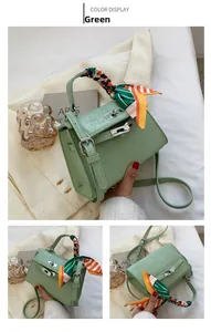 Detail of green embossed crossbody bag with silk scarf handle and metal lock buckle