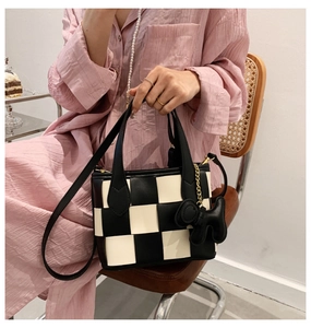 Détail du sac seau à carreaux avec breloque chien et bandoulière réglable pratique