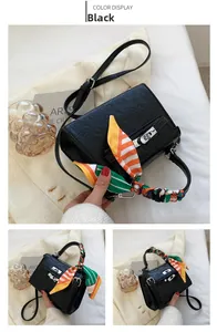 Detail of black embossed leather handbag with silk scarf handle and silver lock