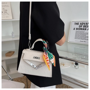 White embossed leather crossbody bag with floral scarf handle shown on a model