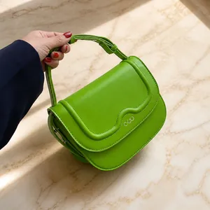 Dettaglio borsa in pelle verde brillante con cuciture a onde e logo argento