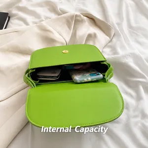 Vista interna della borsa a tracolla verde in pelle PU che mostra la capienza per cellulare