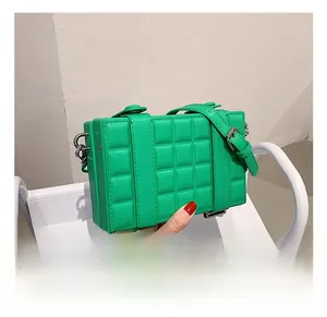 Detail showing the quilted faux leather texture and silver metal hooks of this green bag