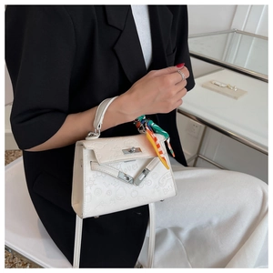 Detail of white Kelly-style handbag with cartoon embossing and floral silk scarf handle