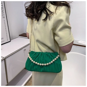 Détail du sac nuage plissé émeraude avec texture soie et poignée de perles élégantes