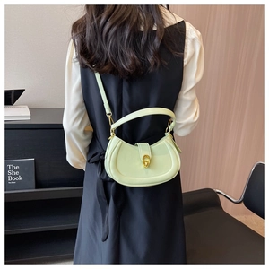 Detailed back view of a mint green half-moon leather bag with golden buckle and straps