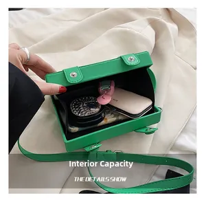 Internal capacity of green plaid crossbody bag showing space for makeup and essentials