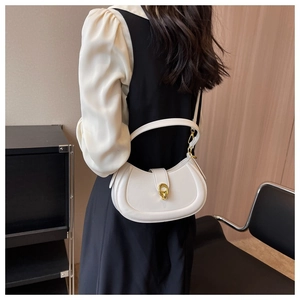 Detail of white crescent bag with gold horsebit buckle and smooth leather texture