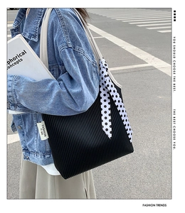 Black pleated tote bag with white handles and a polka dot scarf detail for a chic look