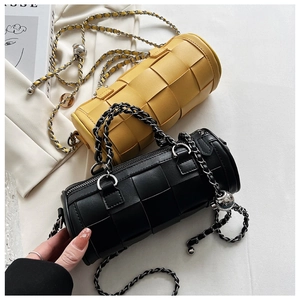 Detailed view of woven leather texture and metal ball chain on cylinder crossbody bags