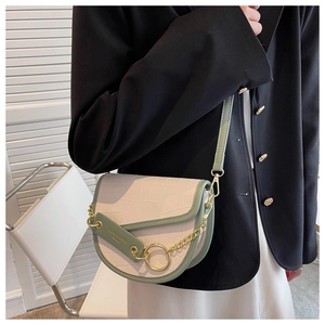 Detail of color-block saddle bag featuring faux crocodile texture and gold chain strap