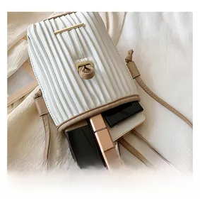 Detail view of the white pleated crossbody bag showing internal capacity for daily items