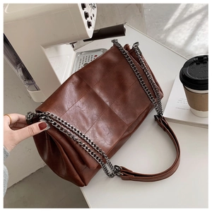 Makroaufnahme der braunen Stepp-Kuriertasche in einem gemütlichen Stadtcafé