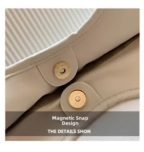Detail of premium gold magnetic clasp and cream leather texture on underarm bag