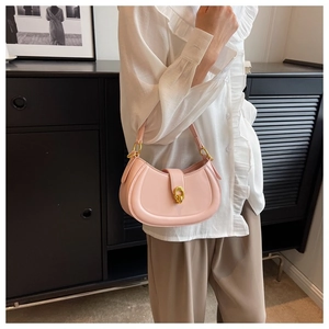 Detailed view of pink leather half-moon bag with elegant vintage gold metal buckle
