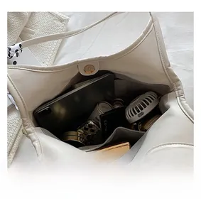 Detailed interior of a spacious beige pleated shoulder bag showing ample storage space