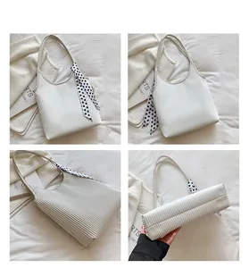 Detail views of cream pleated shoulder bag with polka dot scarf and fashion label