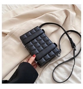 Detail of black plaid structured crossbody bag with woven texture and silver hardware