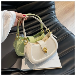 Detail view of light green and white hobo bags with gold ring hardware on a magazine