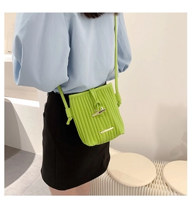 Detail of vibrant green pleated crossbody bag with premium gold metallic hardware