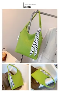 Detail of green pleated shoulder bag with polka dot scarf and fashion label