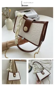Close-up of retro cream leather handbag with embossed patterns and brown trim details