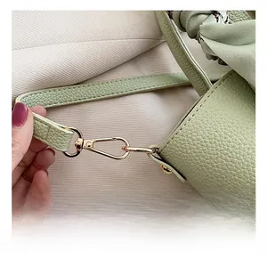 Dettaglio borsa in pelle martellata verde chiaro con gancio girevole in metallo dorato