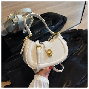 Close-up of white semi-round saddle bag with smooth leather and gold hardware