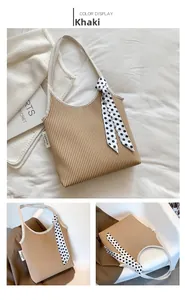 Detail of khaki pleated tote bag with polka dot scarf and fashion label tag