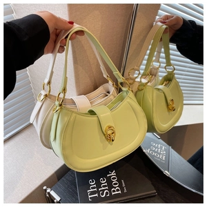 Detail of minimalist half-moon handbags in light green and cream with golden buckles