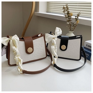 Detail of color-block bags with heart pattern embossing and wood-grain buckle