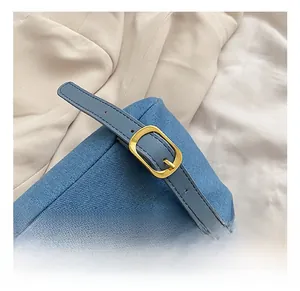Détail de la bandoulière réglable en denim bleu avec boucle en métal doré chic
