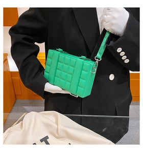 Detailed view of neon green quilted box bag with silver hardware and leather straps