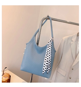 Close-up of light blue pleated tote bag featuring a black and white polka dot scarf