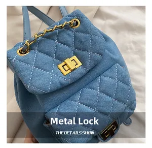 Détail d'un mini sac à dos en denim bleu avec motif matelassé et fermoir doré