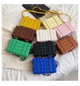 Flat lay of nine colorful quilted plaid crossbody square bags in multiple trendy shades