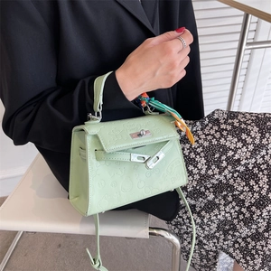 Mint green embossed Kelly bag with printed silk scarf handle and metal bar clasp