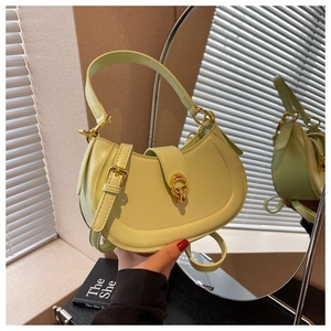 Detail of light green crescent handbag with golden double-ring buckle and leather texture