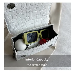Capacité interne du sac bandoulière blanc effet croco avec rouge à lèvres et lunettes
