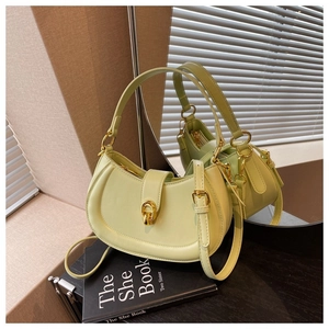 Detail of mint green half-moon crossbody bag with gold hardware and side pleats