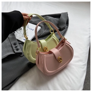 Detail of half-moon leather handbags in green and pink with gold metal hardware