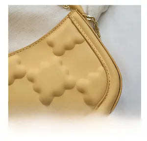 Close-up of cream leather bag featuring 3D quilted texture and precise edge stitching