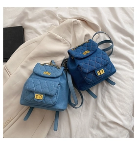Gros plan de mini sacs à dos en denim matelassé bleu clair et foncé avec détails dorés