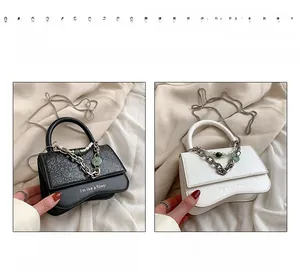 Detail of mini pleated leather bags with chunky metal chains in black and white colors