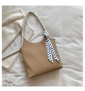 Detail view of khaki pleated shoulder bag with polka dot scarf and branded woven label