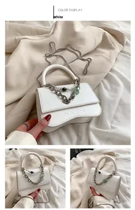 Detail of white pleated leather bag with silver chain, pearls and flower text engraving